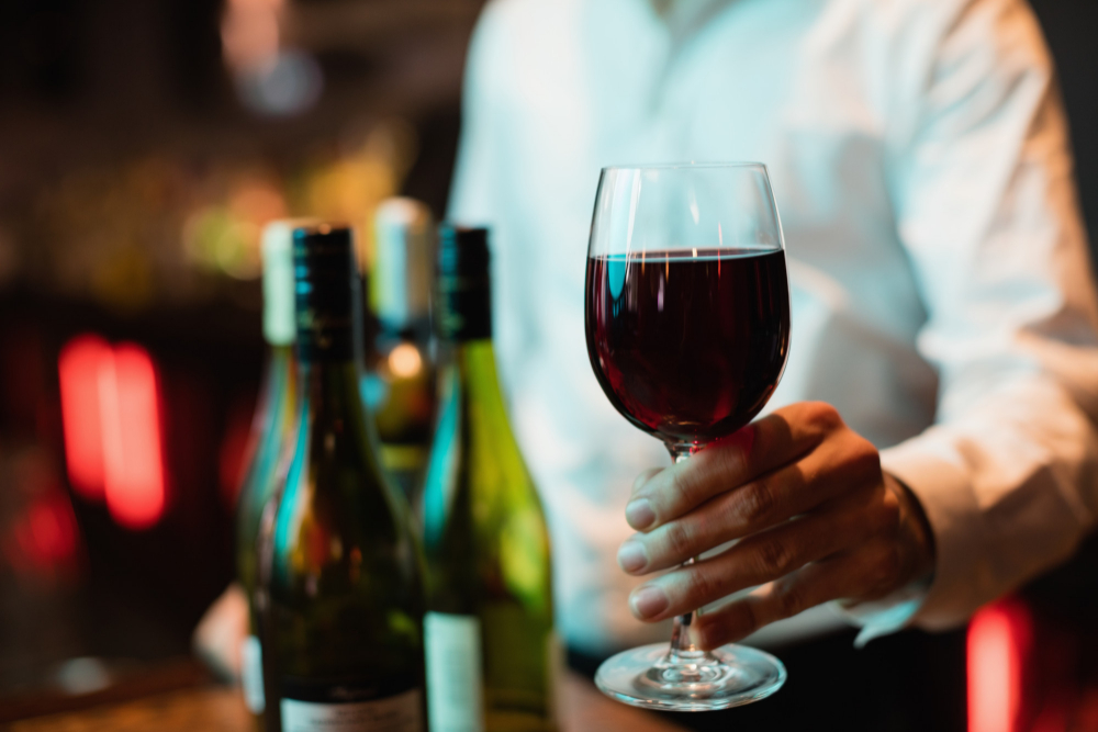 bartender-holding-glass-red-wine